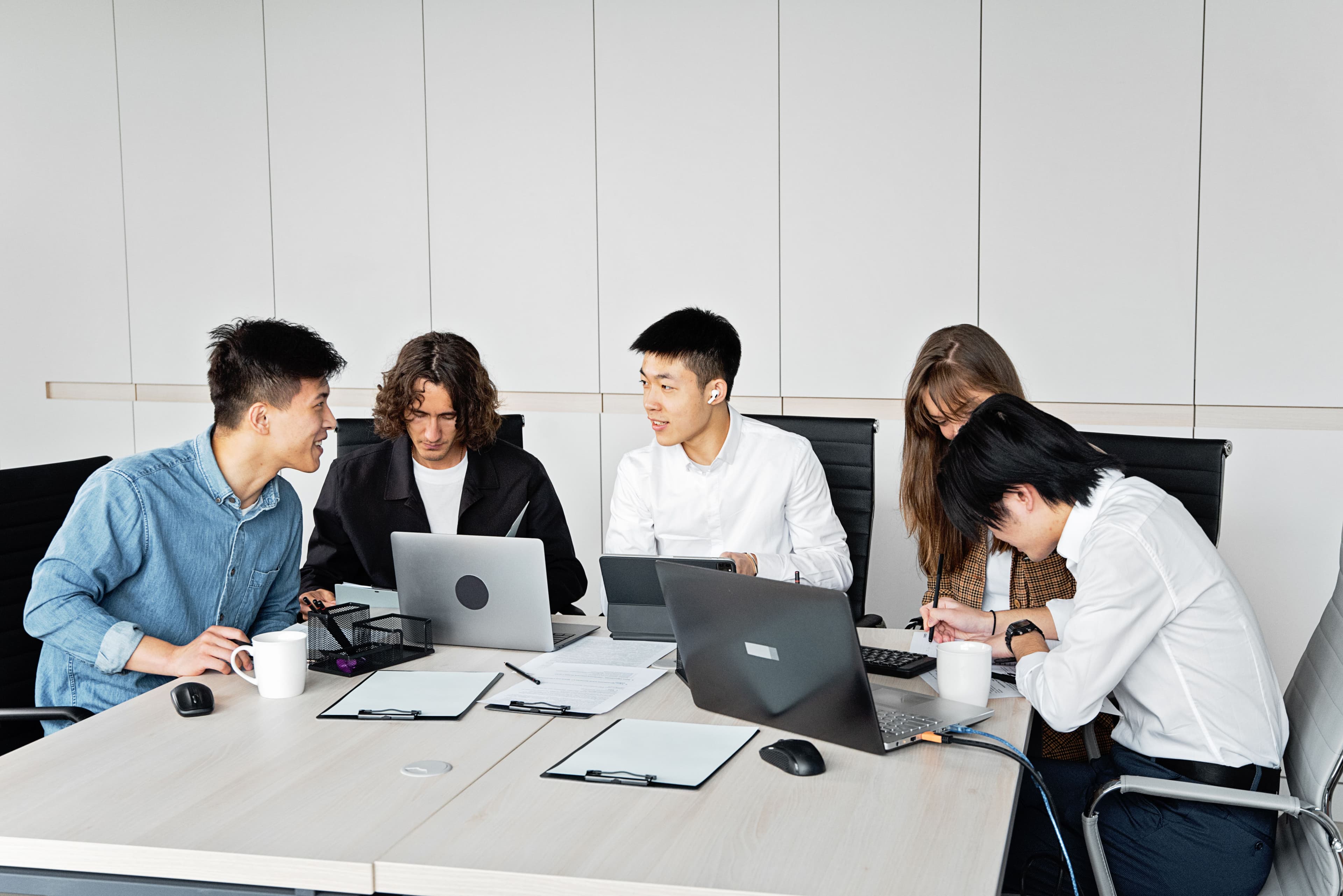 A group of colleagues discussing their work around a meeting table